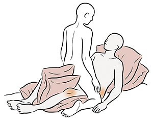 Position sexuelle face à face montrant une personne allongée sur des oreillers avec des oreillers sous et entre les genoux. Une autre personne chevauche la personne étendue. 